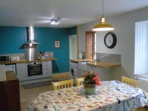 Rowan Cottage, CrannachCottages في غارف: مطبخ مع طاولة عليها إناء من الزهور