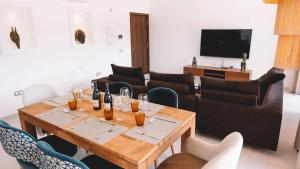 ein Wohnzimmer mit einem Holztisch mit Weingläsern in der Unterkunft Villa privada de lujo con piscina, Sabi Sabi in Corralejo
