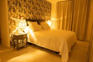 ein Schlafzimmer mit einem Bett und einem Tisch mit einer Lampe in der Unterkunft Villa privada de lujo con piscina, Sabi Sabi in Corralejo + 21 Fotos