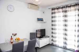 a dining room with a table and a television at Apartment Zora in Vodice