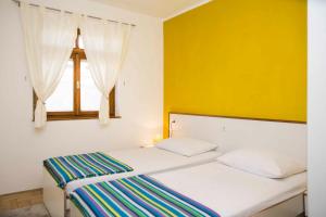 a bedroom with two beds and a window at Apartment Zora in Vodice