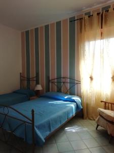 sypialnia z 2 łóżkami i oknem w obiekcie Casa Vacanza Orizzonte w mieście Marina di Camerota
