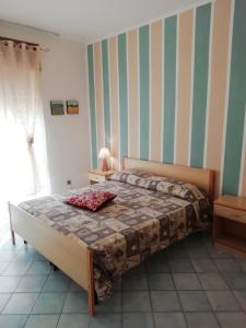 sypialnia z łóżkiem i ścianą w paski w obiekcie Casa Vacanza Orizzonte w mieście Marina di Camerota