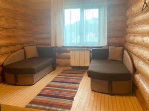 ein Wohnzimmer mit 2 Stühlen und einem Fenster in der Unterkunft KATERINA in Slawske