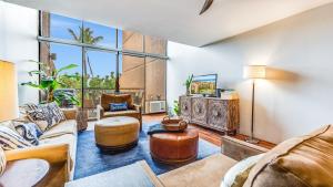a living room with furniture and a large window at Hale O Kalani condo in Kahana