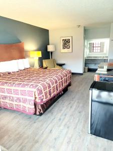 a hotel room with a bed and a television at Best Price Motel & Suites in Orange