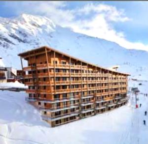 un edificio en la nieve frente a una montaña en Bienvenue chez nous, en Arc 2000