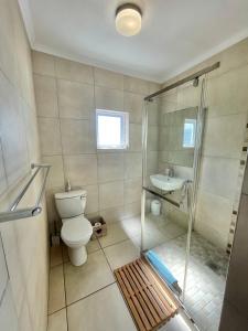 a bathroom with a shower and a toilet and a sink at Sail Away Studios in Simonʼs Town +47 photos