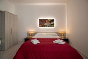 
a bedroom with a bed, a dresser and a painting on the wall at CasaTrapani Rooms & Apartments in Trapani
