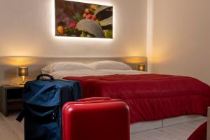 a bedroom with a bed with two suitcases in front of it at CasaTrapani Rooms & Apartments in Trapani