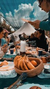 eine Gruppe von Menschen, die an einem Tisch mit Essen sitzen in der Unterkunft אוהל הזית in Maʼor