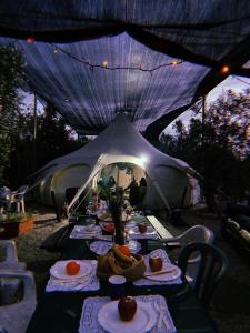 un tavolo in tenda con cibo sopra di אוהל הזית a Maʼor