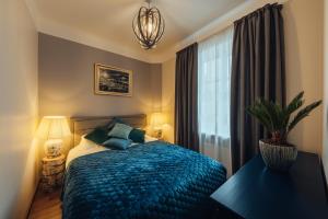 um quarto com uma cama azul e uma janela em Rezidence Liepas em Liepāja