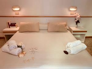 a bedroom with a large bed with towels on it at HOTEL LABRADOR in Cattolica