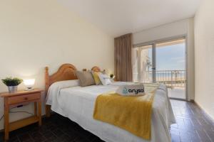 a bedroom with a bed with a view of the ocean at Apartamentos DMS V Arysal in Cambrils