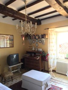 a living room with a chandelier and a tv at Barga Lucca Centro Storico Con giardino in Barga