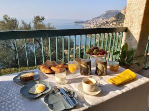 a table with breakfast foods and coffee on a balcony at Soutariba in Roquebrune-Cap-Martin