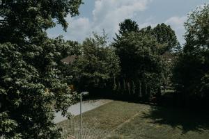 a fence in a yard with trees and a street light at Platán in Siófok