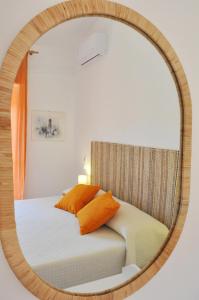 einen Spiegel, der ein Bett im Schlafzimmer reflektiert in der Unterkunft Casa Benny difronte al mare in Oliveri