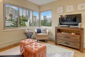 a living room with a tv and a chair and windows at Eclectic Downtown & Cap Hill King bed & Kitchen in Seattle