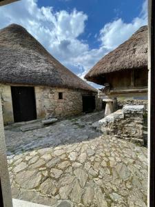 2 grandes edificios de piedra con techo de paja y un cielo en Casa Casoa en Piornedo