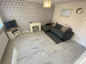 a living room with a couch and a tv at GARDNER HOLIDAYS HOUSE in Manchester