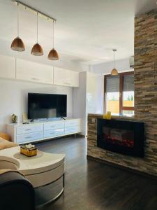 a living room with a large television and a fireplace at Copou Residence in Iaşi