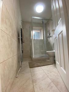 a bathroom with a shower and a toilet and a sink at GARDNER HOLIDAYS HOUSE in Manchester