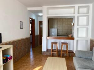 a living room with a couch and a kitchen at Apartamentos Las Palmeras I in Puerto del Carmen