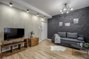 a living room with a couch and a flat screen tv at Niron Apartamenty Spacerowa in Piła
