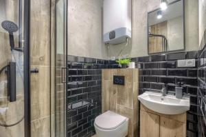 a bathroom with a toilet and a sink and a shower at Niron Apartamenty Spacerowa in Piła