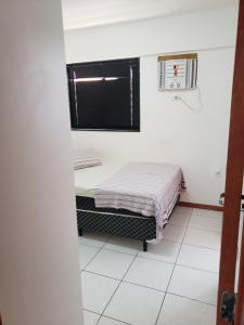 Habitación pequeña con cama y ventana en Apt 2 quartos acomoda 10 pessoas a 450 metros da praia de Jatiúca, en Maceió
