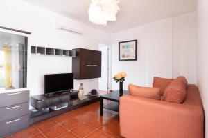 un soggiorno con un divano e una televisione di Bubu Beach 3 a Los Cristianos