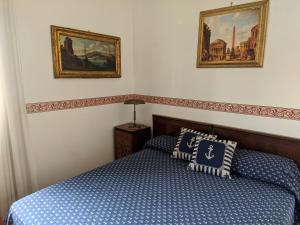 um quarto com uma cama e duas fotografias na parede em Attico Panoramico Vista Mare em Anzio