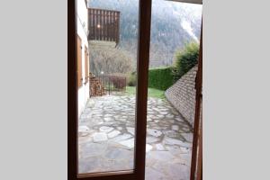a window view of a stone walkway from a house at Appartamento IL QUADRIFOGLIO in Saint-Oyen
