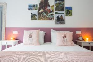a bedroom with a white bed with pink walls at Bicycle Villas - AL in Ponta Delgada
