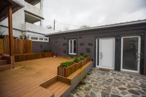 a backyard with a wooden deck and a house at Bicycle Villas - AL in Ponta Delgada