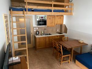 a small kitchen with a table and a bunk bed at Cihlářka Apartmán 109 - Pec pod Sněžkou Černá Hora in Černý Dŭl