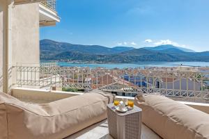 balcón con sofás y vistas a la ciudad en Alexandra's Cozy Sea View Apartment, en Argostoli