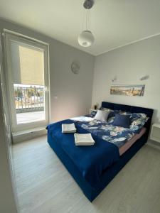 a bedroom with a blue bed with two towels on it at Apartament w Słonecznej Dolinie Jastrzębia Góra in Jastrzębia Góra
