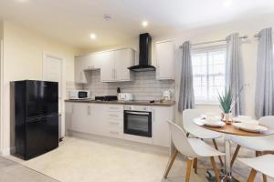 
a kitchen with a stove a refrigerator and a microwave at 2 Bedroom Town Centre Apartment in Cheltenham
