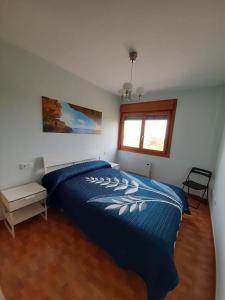 巴雷羅斯的住宿－Lugomar，一间卧室设有蓝色的床和窗户。
