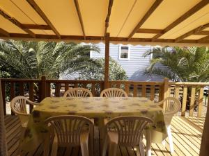 une table et des chaises sur une terrasse dans l'établissement mobil home neuf 2 chambres 6 personnes Saint Aygulf plage, à Fréjus