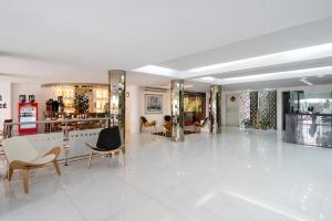 eine große weiße Lobby mit Stühlen und Tischen in der Unterkunft Hotel Romimar 3* Sup in Punta del Este