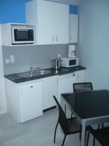Il comprend une cuisine équipée d'un évier, d'un four micro-ondes et d'une table. dans l'établissement VILLA MARILOU 5 personnes, à La Faute-sur-Mer 14 autres photos