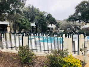 a white fence in front of a swimming pool at Springwood Villas with pool excess half a mile from beach in Hilton Head Island