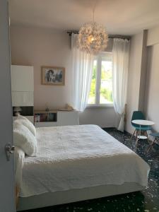 1 dormitorio con cama blanca y lámpara de araña en Sea view with terrace, La Casa Di Christine, en Monterosso al Mare