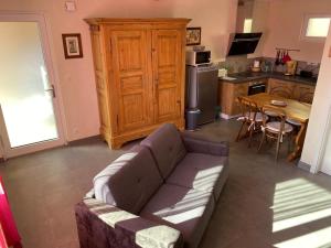 a living room with a couch and a kitchen at Le Noyer in Cosswiller