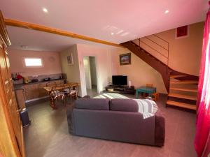 ein Wohnzimmer mit einem Sofa und einer Küche in der Unterkunft Le Noyer in Cosswiller