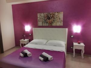 ein lila Schlafzimmer mit einem Bett mit zwei Kissen darauf in der Unterkunft Da Luigi locazioni brevi turistiche in Monopoli